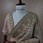 Dusty pink georgette saree with Swarovski stone jaal work and multicolor floral scalloped border on mannequin.